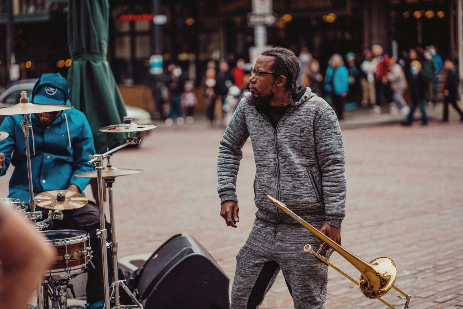 A street band mid-set, a trombonist in front of a drummer at his kit